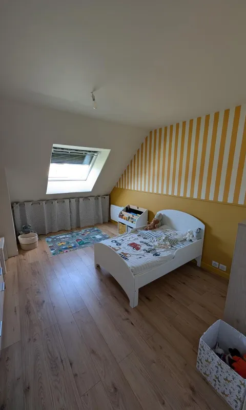 Peinture décorative des murs d’une chambre d’enfant avec rayures jaunes et blanche